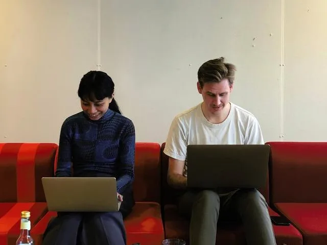 Two people sitting on a couch with laptops on their knees Real estate scams