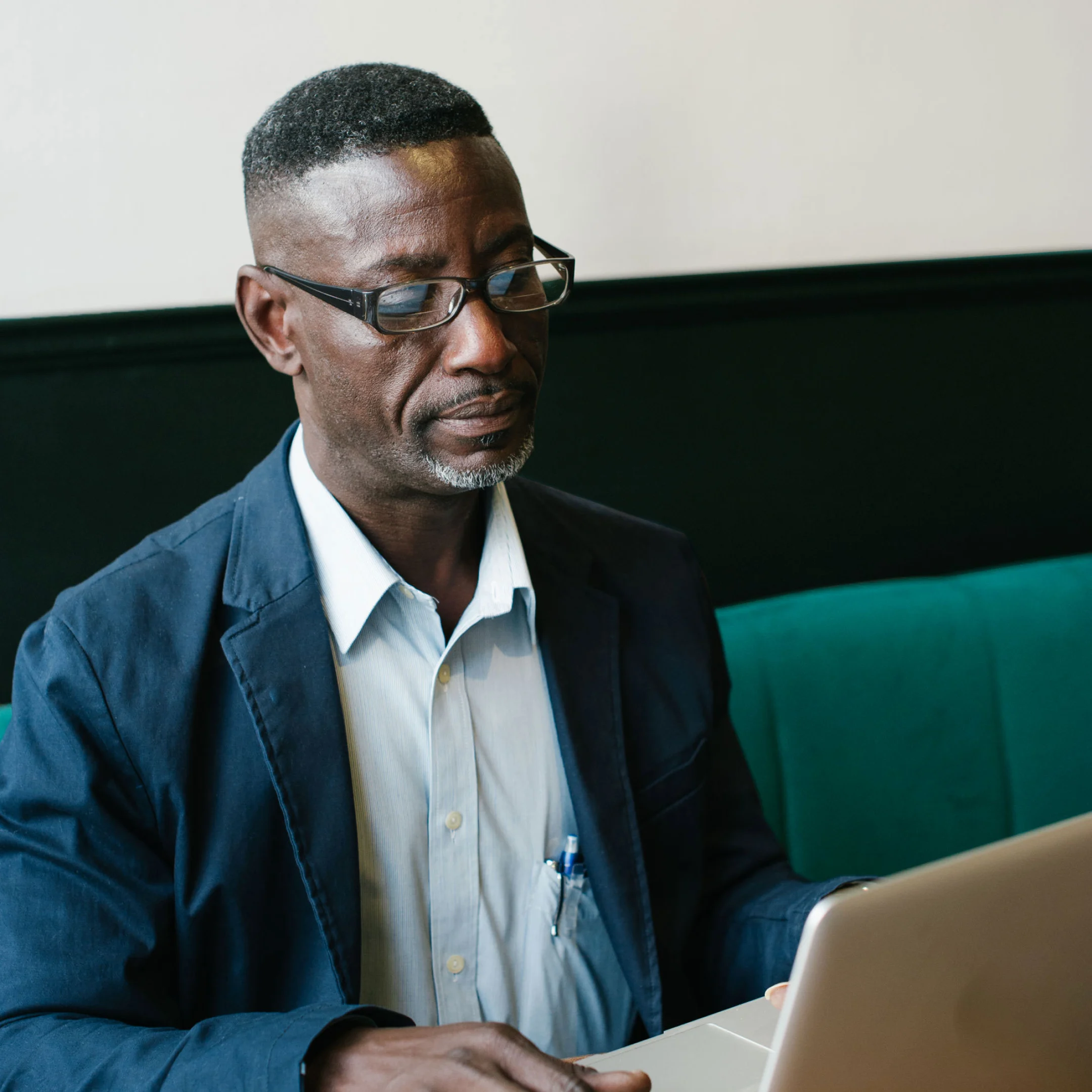 the case for leaving reviews A man in casual business wear sits with his laptop on a green sofa